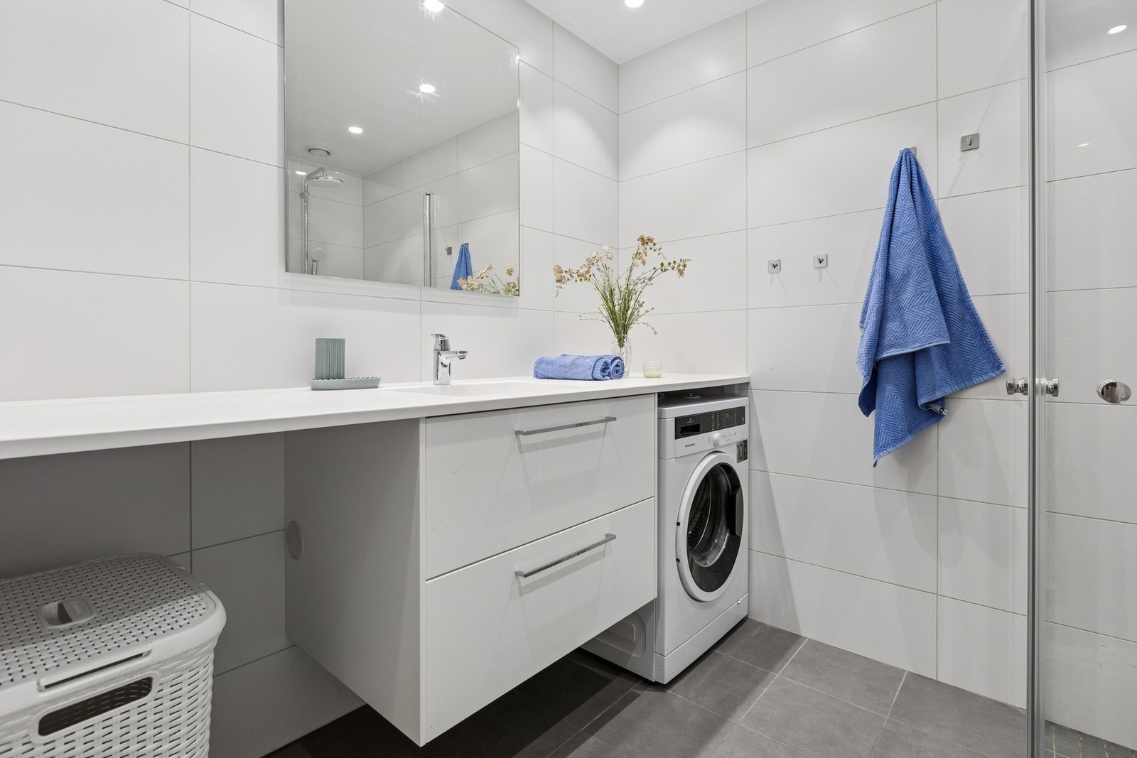 Rommet er smart innredet med heldekkende servantbenk med god oppbevaring, speilskap og dusjssone med glassvegger. Galleribilde