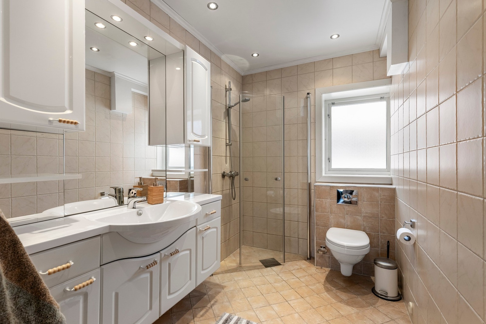 Boligen har et romslig og praktisk bad med flislagte gulv og vegger, samt gulvvarme som gir god komfort. Galleribilde