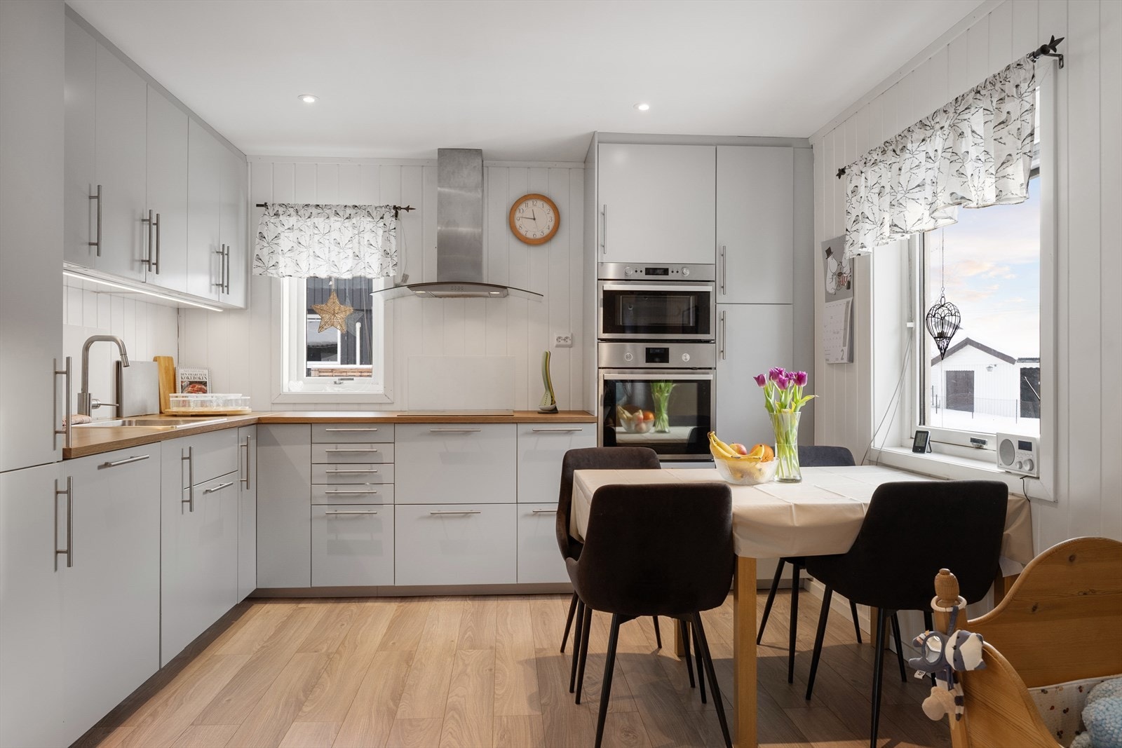 Tidløs kjøkkeninnredning med glatte fronter og laminert benkeplate, og integrerte hvitevarer. Galleribilde