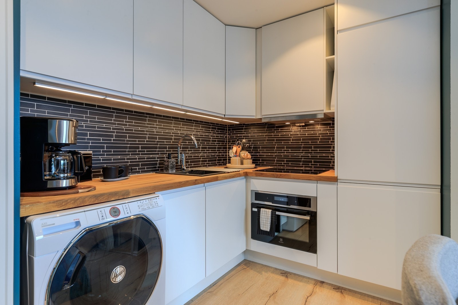 Pent kjøkken i hvite fronter med god skap og benkeplass. Alt av hvitevarer følger med. Galleribilde