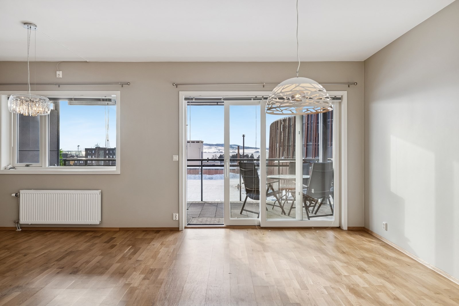 Skyvedøren i malt tre åpner opp mot balkongen og slipper inn rikelig med dagslys. Galleribilde