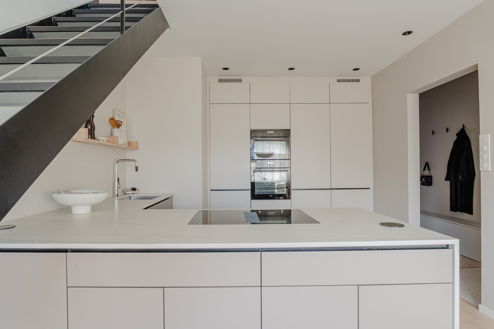 Luftig og sosial utforming med takhøye overskap og kjøkkenøy med integrert platetopp og ventilator. Galleribilde