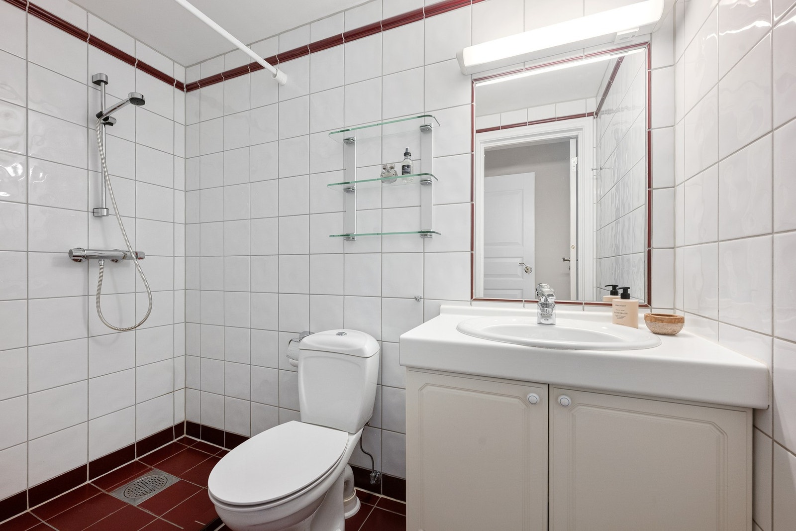 Praktisk og funksjonelt bad med dusjhjørne og god oppbevaringsplass i servantskap. Galleribilde