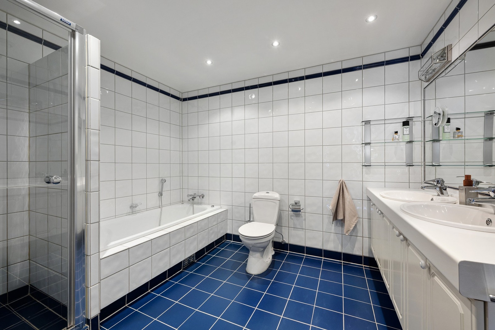 Romslig bad tilknyttet hovedsoverommet, med flislagte overflater og behagelig belysning med downlights i himling. Galleribilde