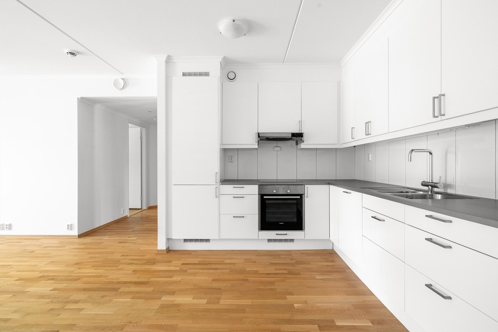 Kjøkkenet har integrerte hvitevarer som oppvaskmaskin, platetopp, stekeovn og kjøl/fryseskap, og over kokesonen er det ventilator med avtrekk via balansert anlegg. Galleribilde