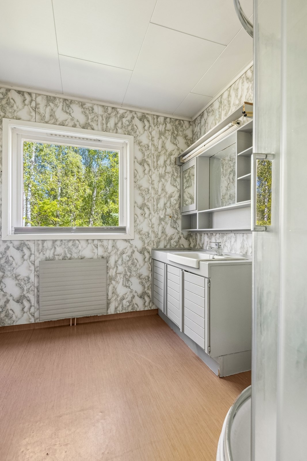 Baderommet i 1. etasje er fra byggeåret, og har belegg på gulvet og baderomsplater på veggene. Galleribilde