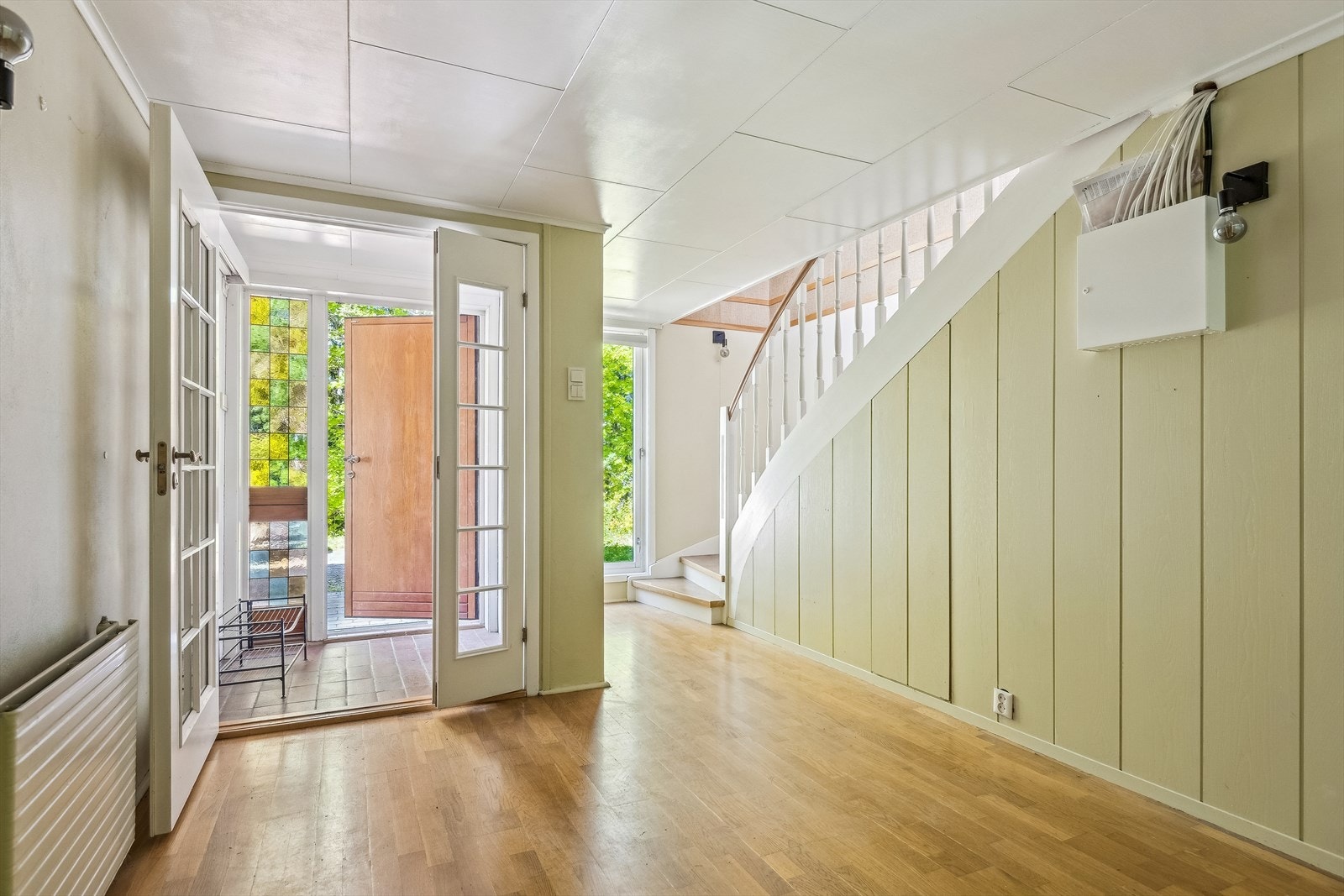 Velkommen inn i en lys hall med adkomst til stue og en malt tretrapp nede i sokkeletasjen. Galleribilde