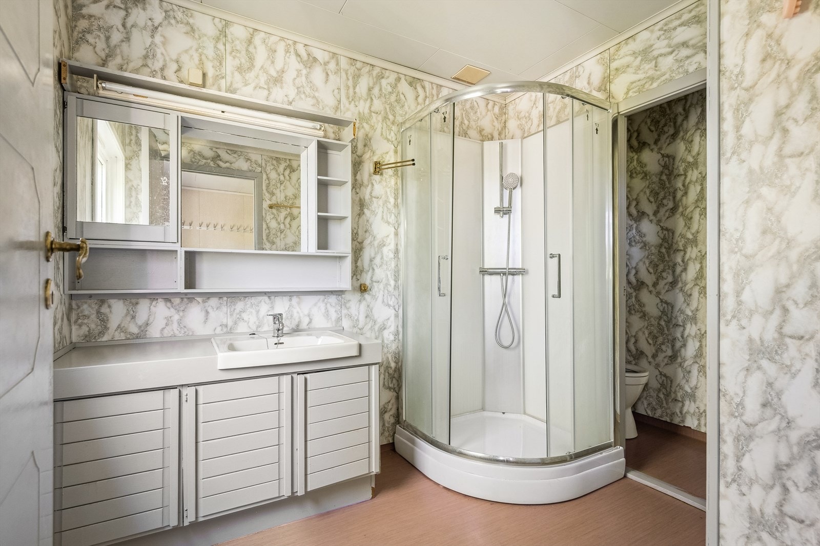 Badet er utstyrt med servantinnredning, toalett i separat rom og dusjkabinett. Galleribilde