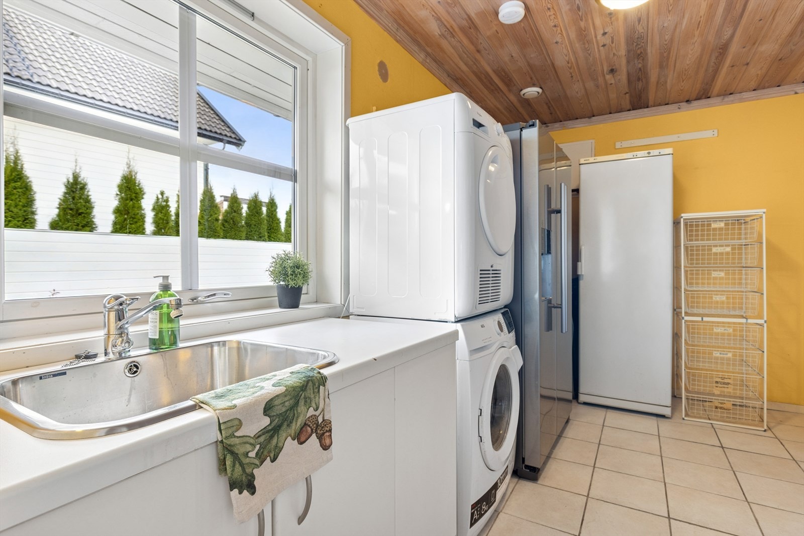 Praktisk vaskerom med flislagt gulv og godt med skapplass, og her medfølger alle hvitevarer. Galleribilde