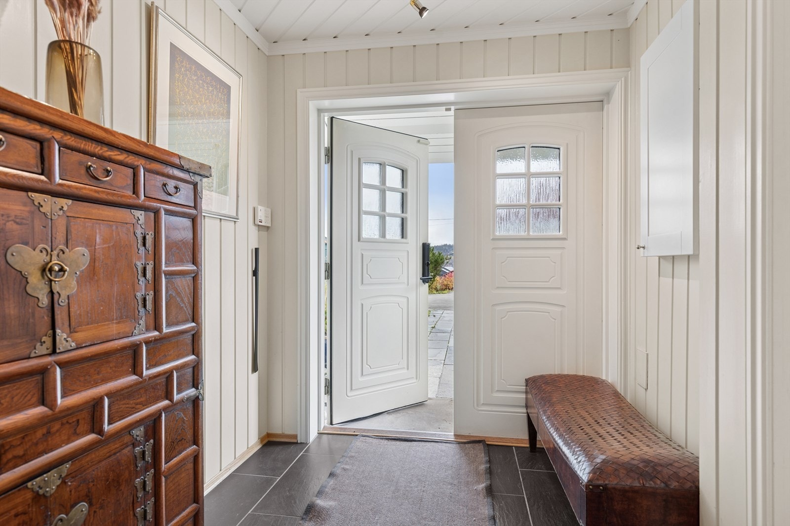 Boligen har inngang i underetasjen med fliser på gulvet og malt panel på veggene. Galleribilde