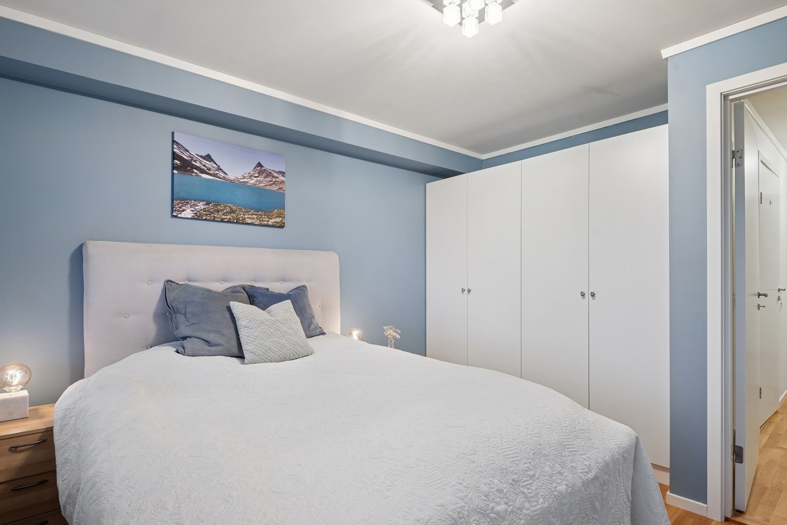 Hovedsoverommet er stort og luftig med god plass til dobbeltseng med tilhørende nattbord og garderobeskap Galleribilde