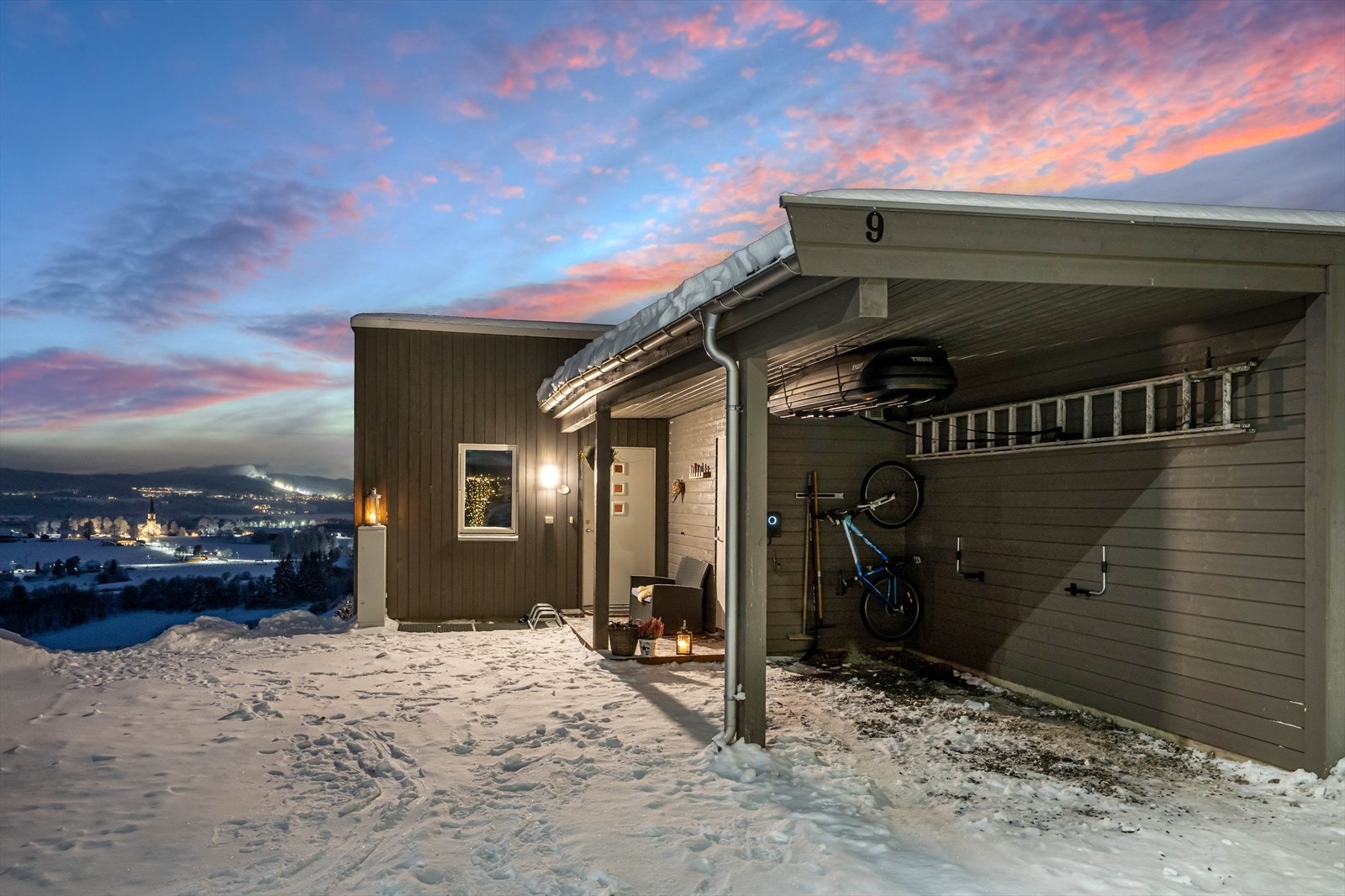 Det er godt med biloppstillingsplasser i egen caport og på egen gårdplass. Det er elbil-lader i carporten og en hyggelig velkomsplatting foran inngangsdøren og den praktiske sportsboden Galleribilde