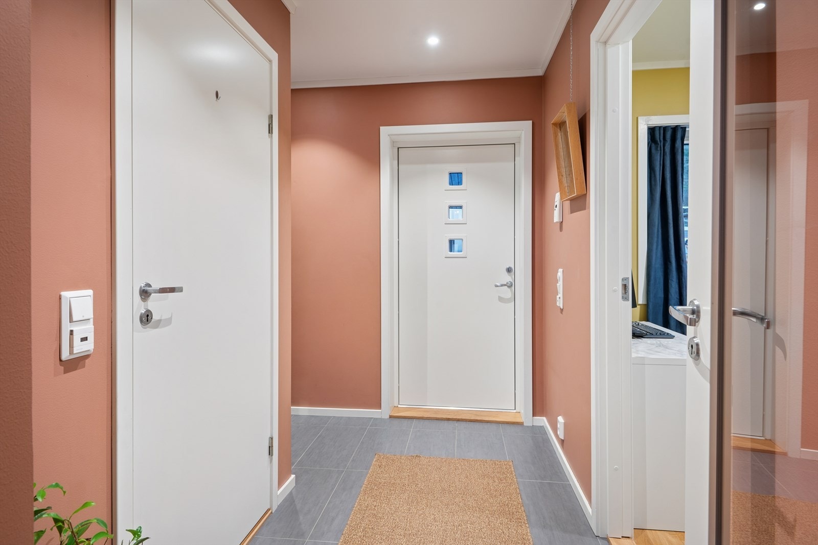 Velkommen inn! Entreen er pent innredet med fliser på gulv med underliggende varme, glattmalte vegger og downlightsbelysning i himling Galleribilde