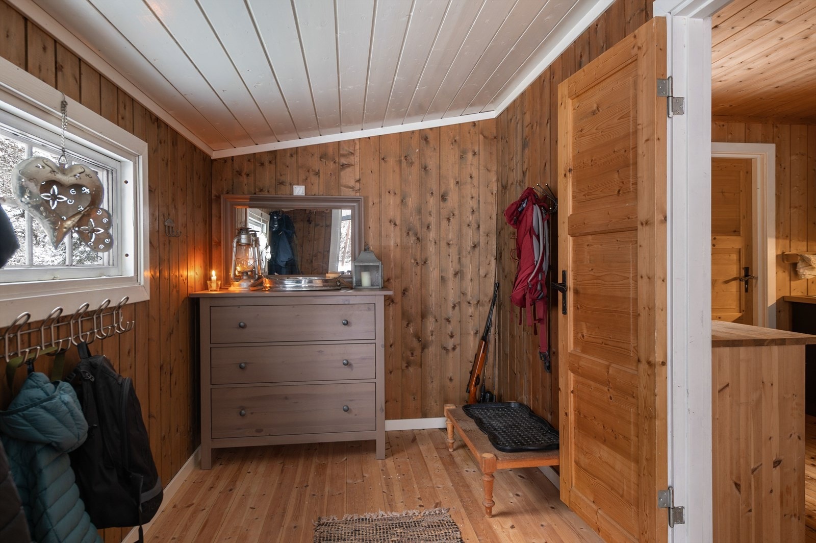 Furugulv og panelvegger skaper en varm og innbydende entré. Galleribilde