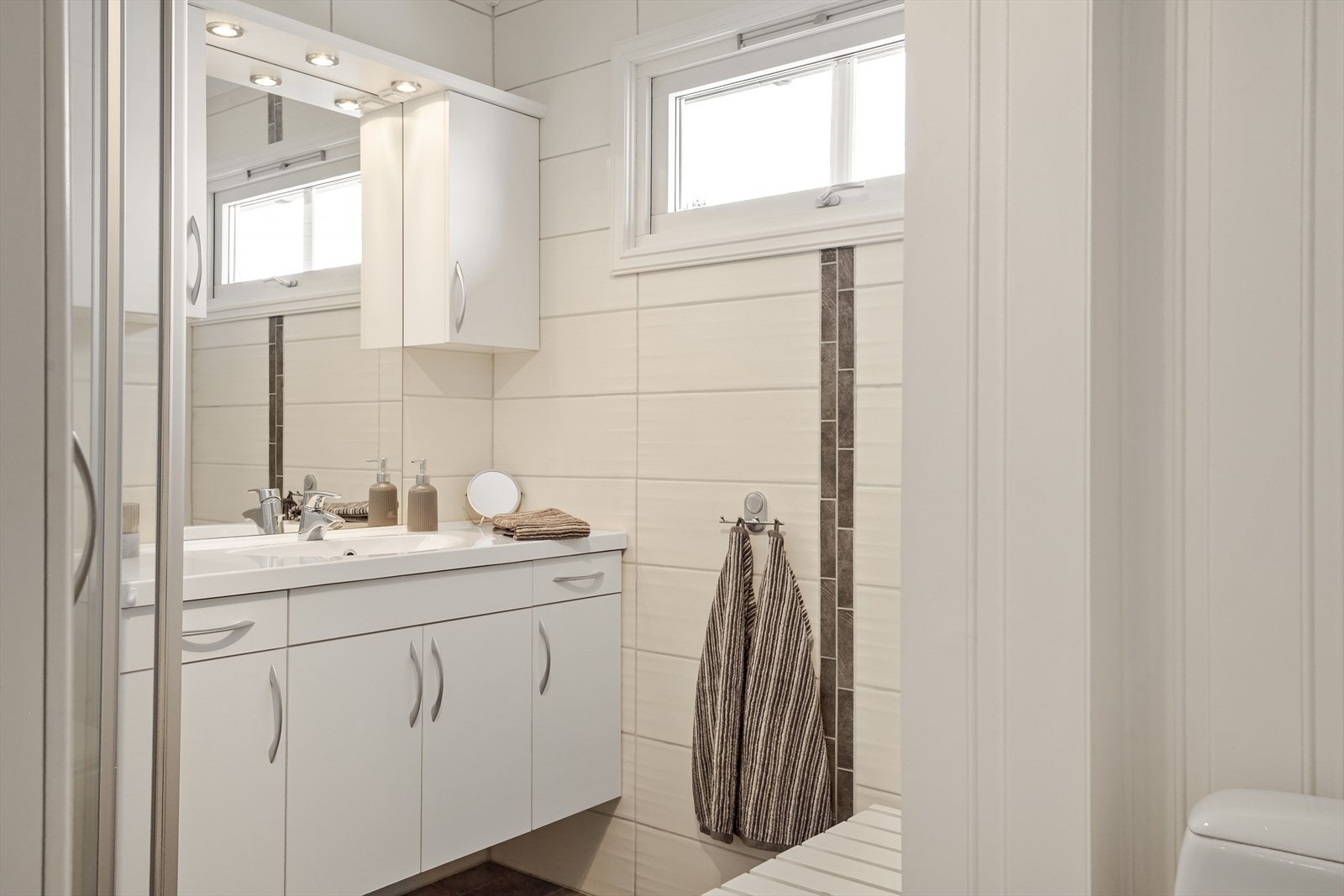 Baderommet i 1.etasje har flislagte vegger kombinert med panel, og elektriske varmekabler i gulvet. Galleribilde