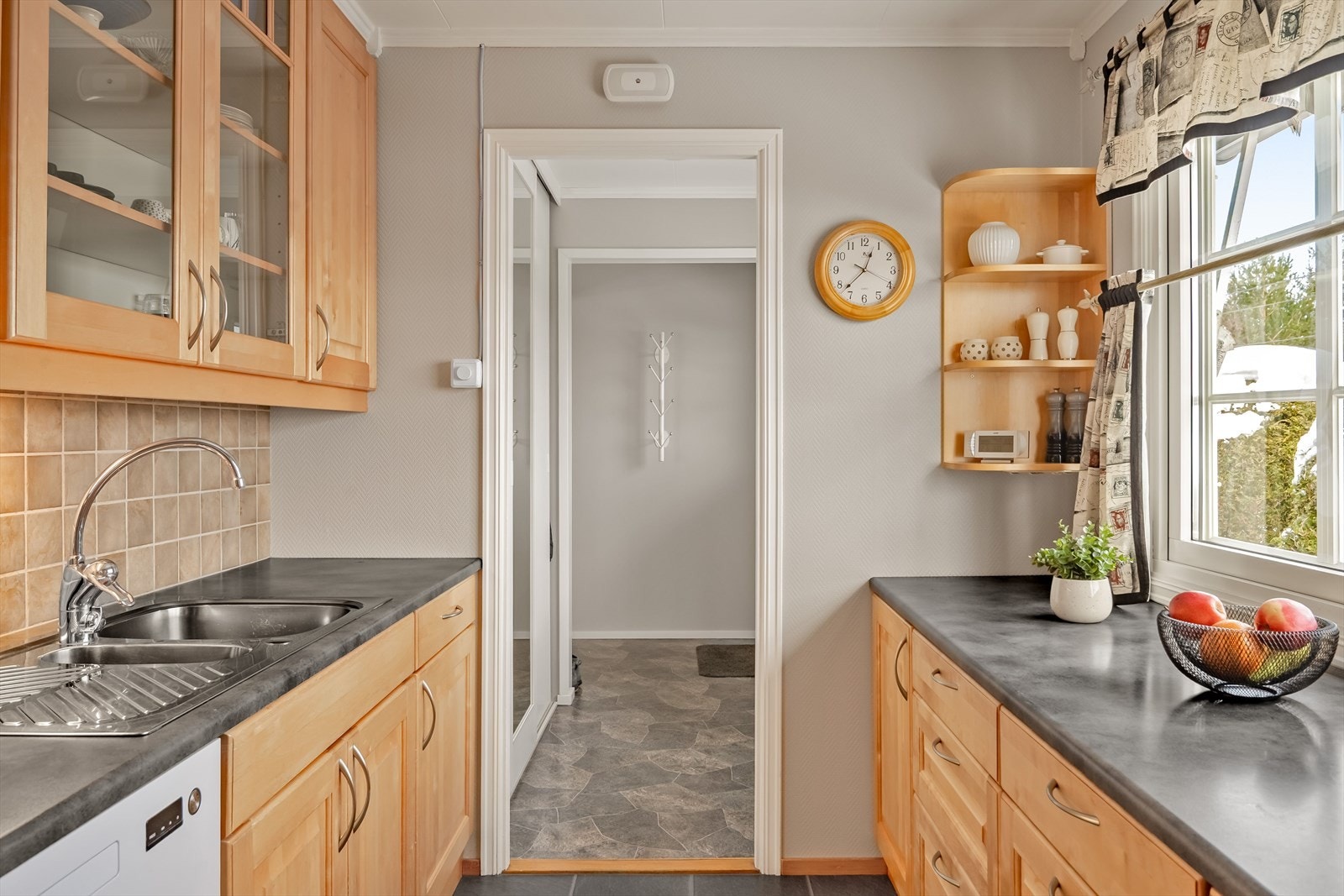 Kjøkkenet har profilerte fronter og laminat benkeplate med fliser i benkeryggen. Galleribilde