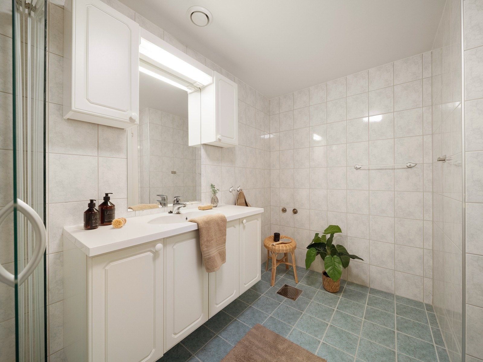 Badet er innredet med toalett, servant i møbel og dusjhjørne. Galleribilde