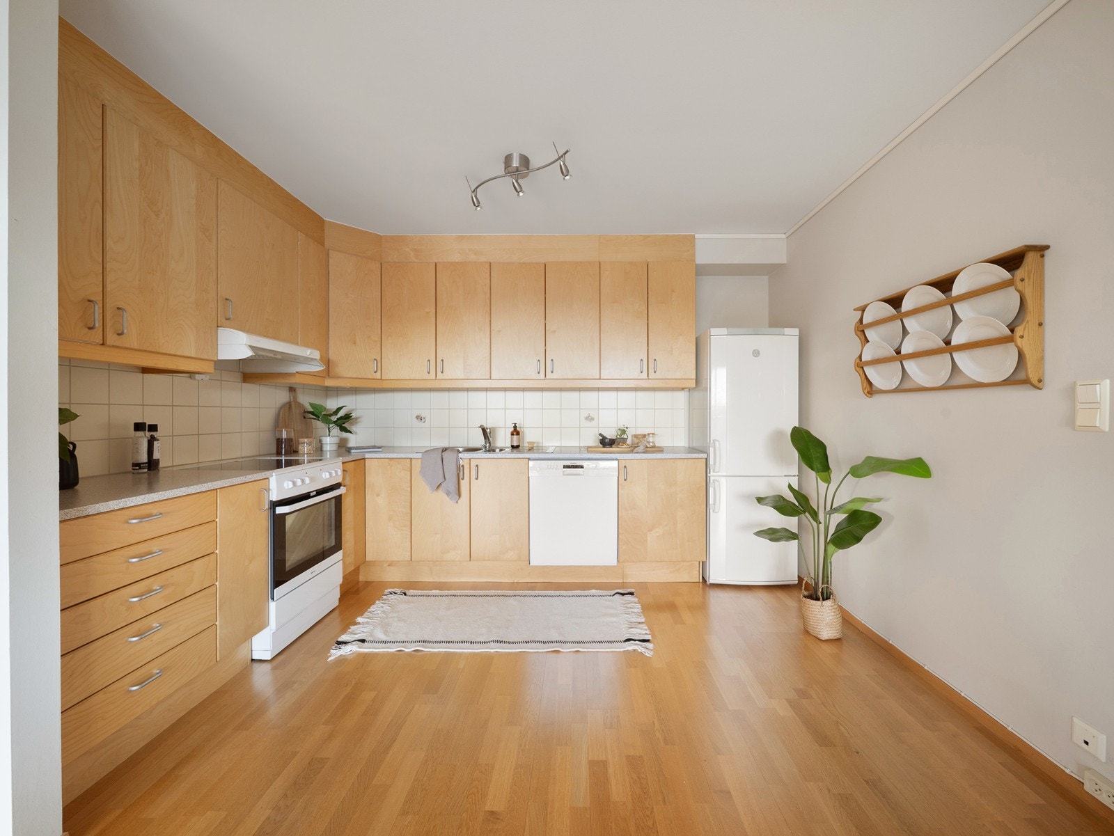 Kjøkkeninnredningen med slette fronter i bjørk utførelse og benkeplate av laminat. Galleribilde