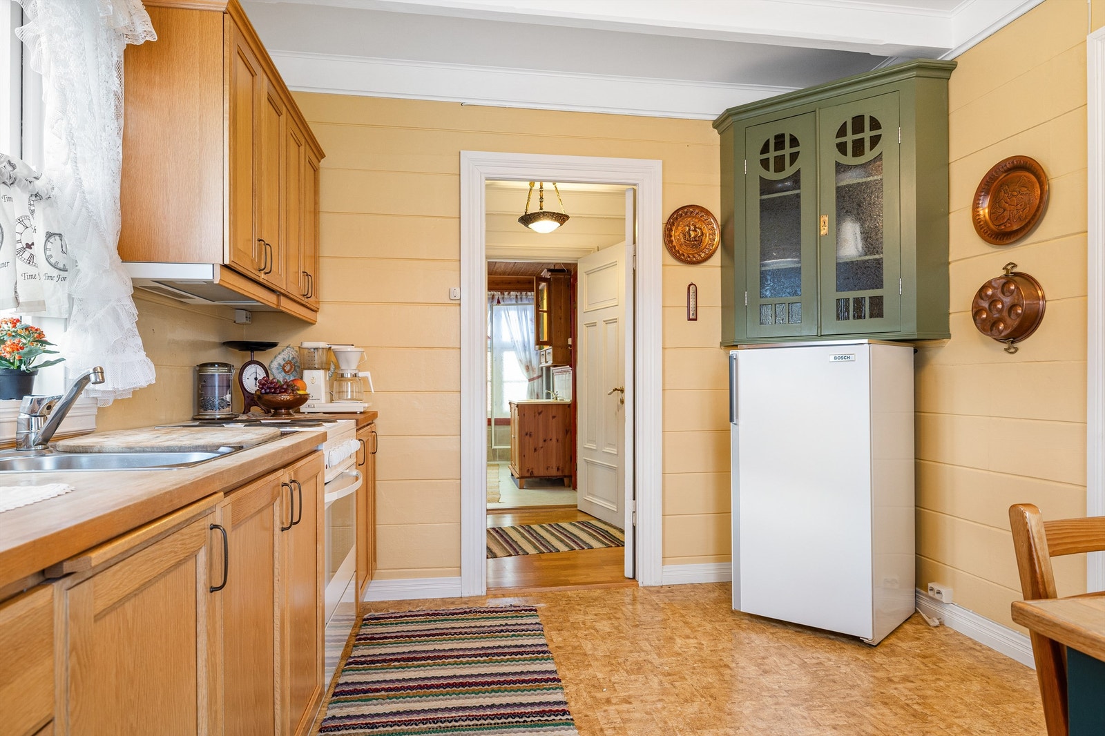 Sjarmerende kjøkken med lyse vegger og praktisk innredning Galleribilde