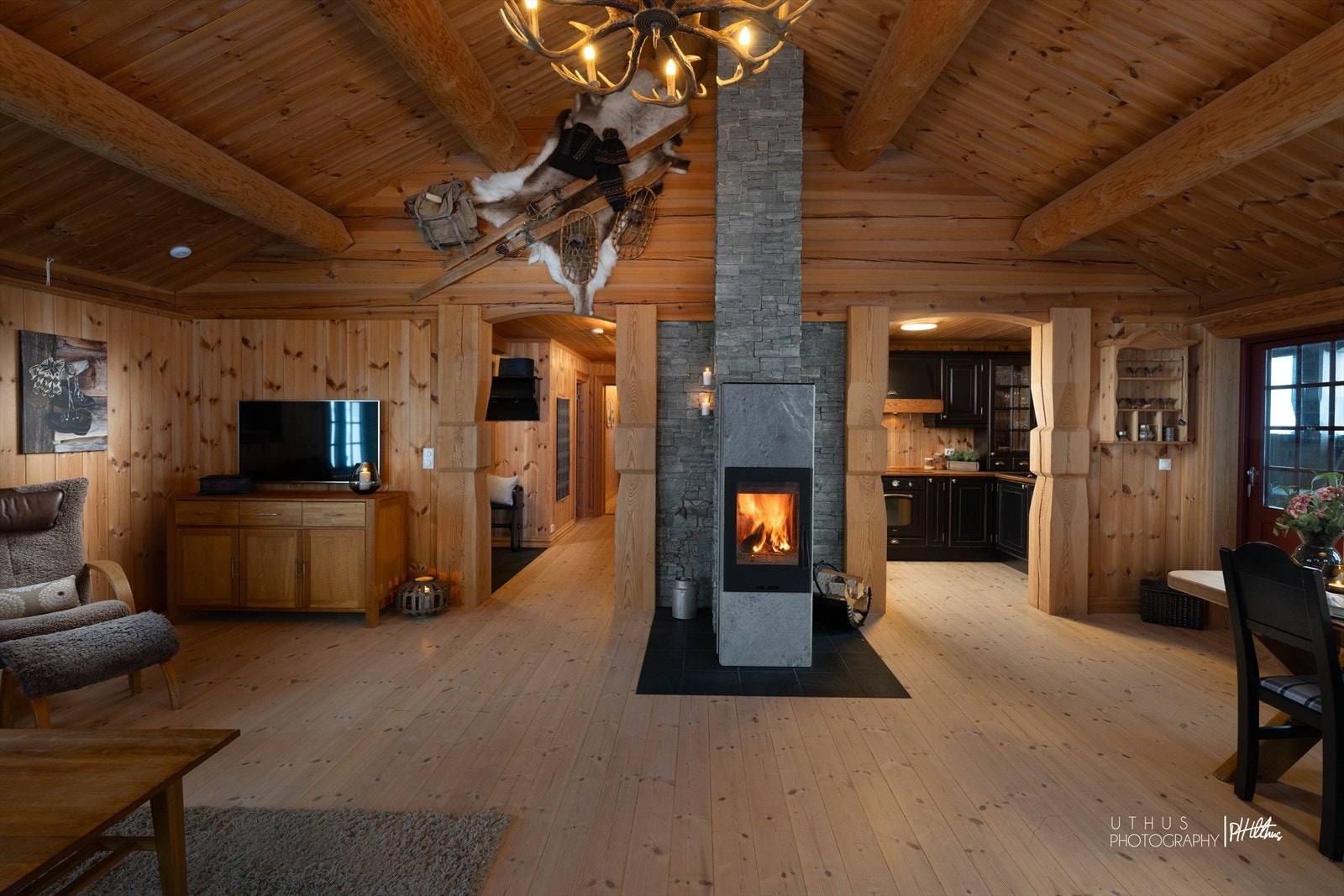 Stuen har åpen himling med fem majestetiske tømmerstokker med en takhøyde på hele 4,5 meter Galleribilde