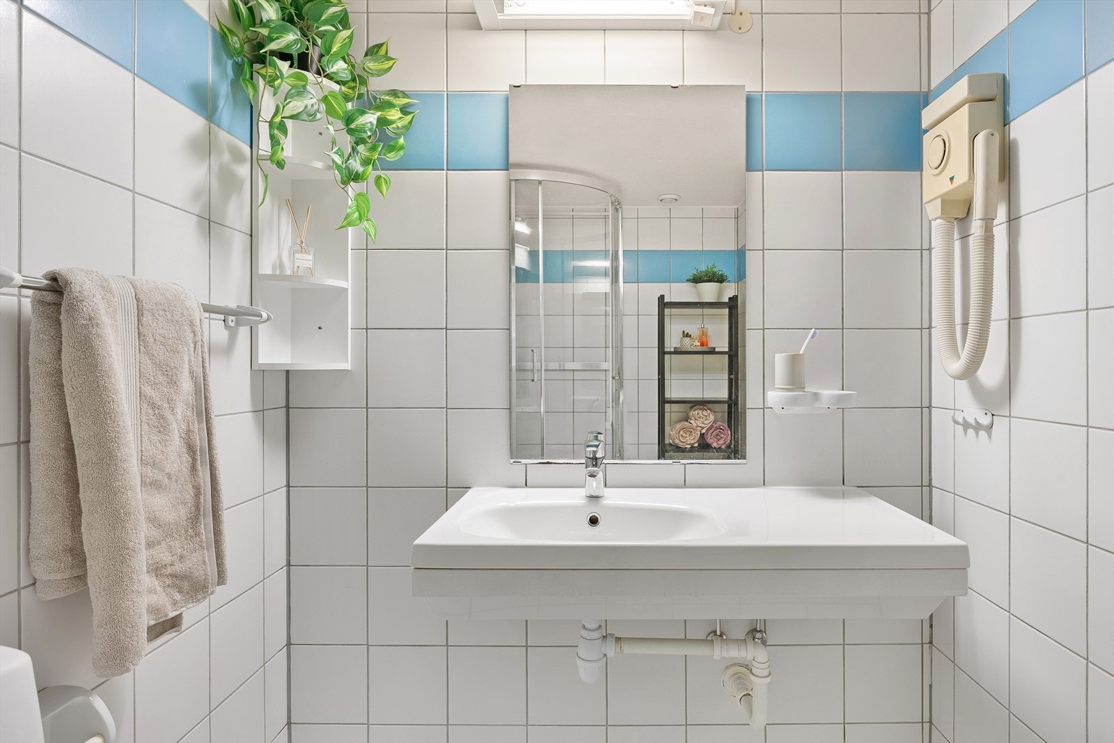 Innredningen gir god plass til oppbevaring av håndduker og baderomsartikler. Badet er videre utstyrt med nytt dusjkabinett fra 2020 og nytt toalett fra 2022. Galleribilde