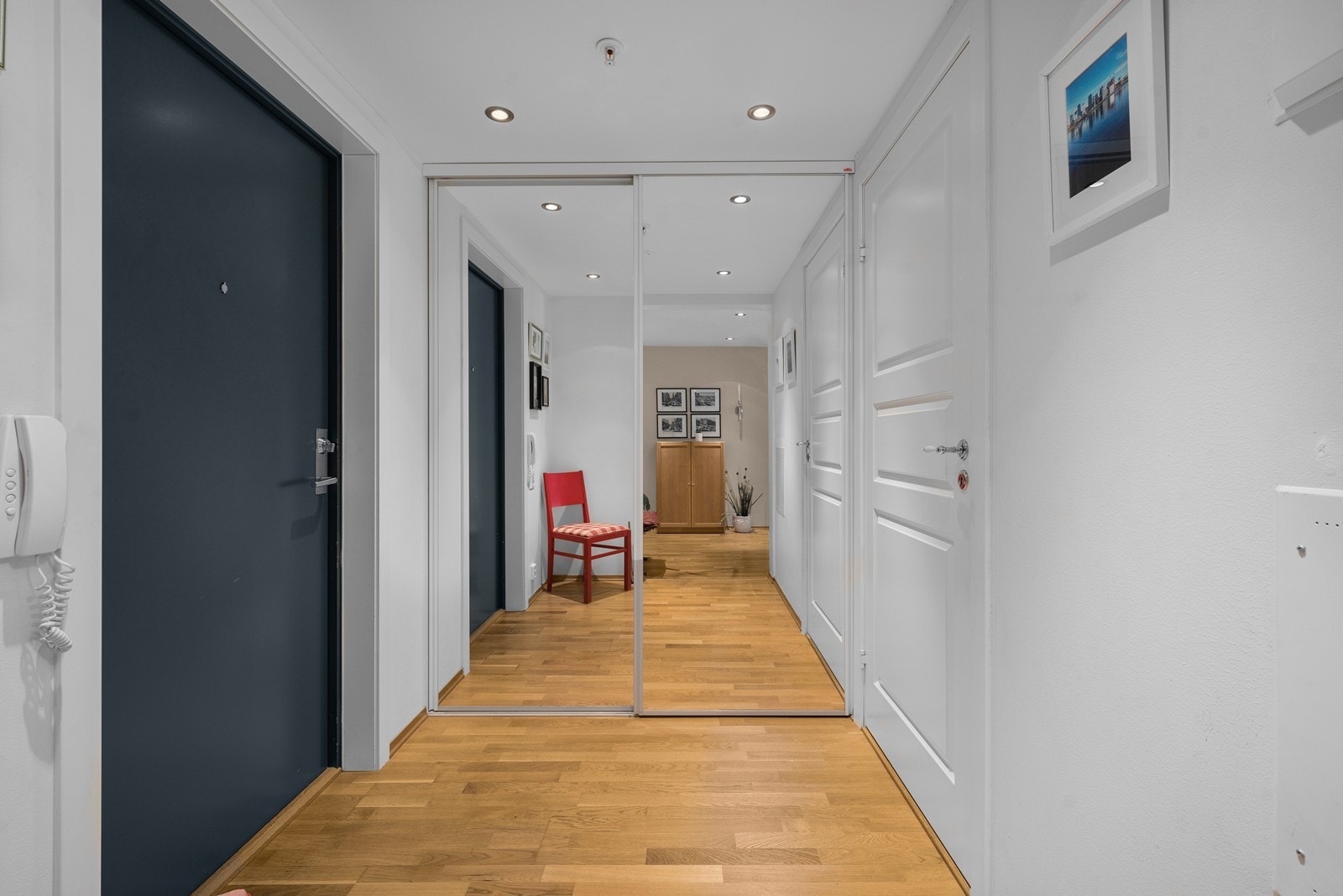 Innbydende entré med en stor skyvedørsgarderobe med speilfronter. Galleribilde