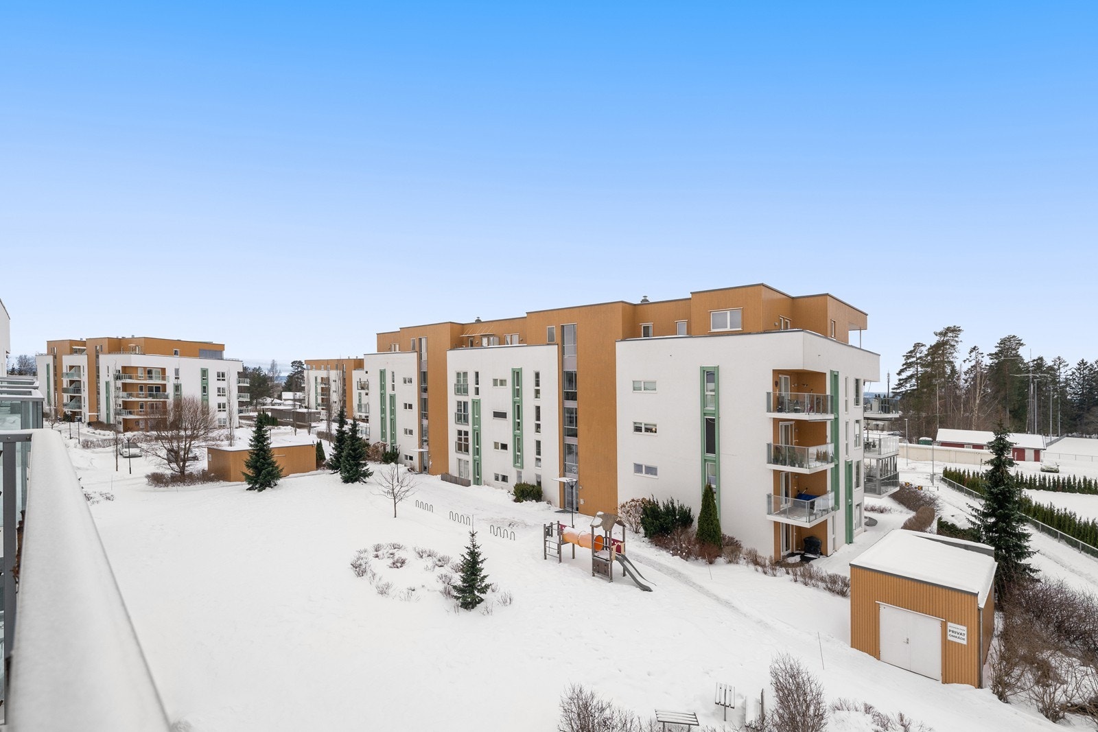 Utsyn over sameiets velholdte fellesarealer med lekeplass og grøntområder. Galleribilde