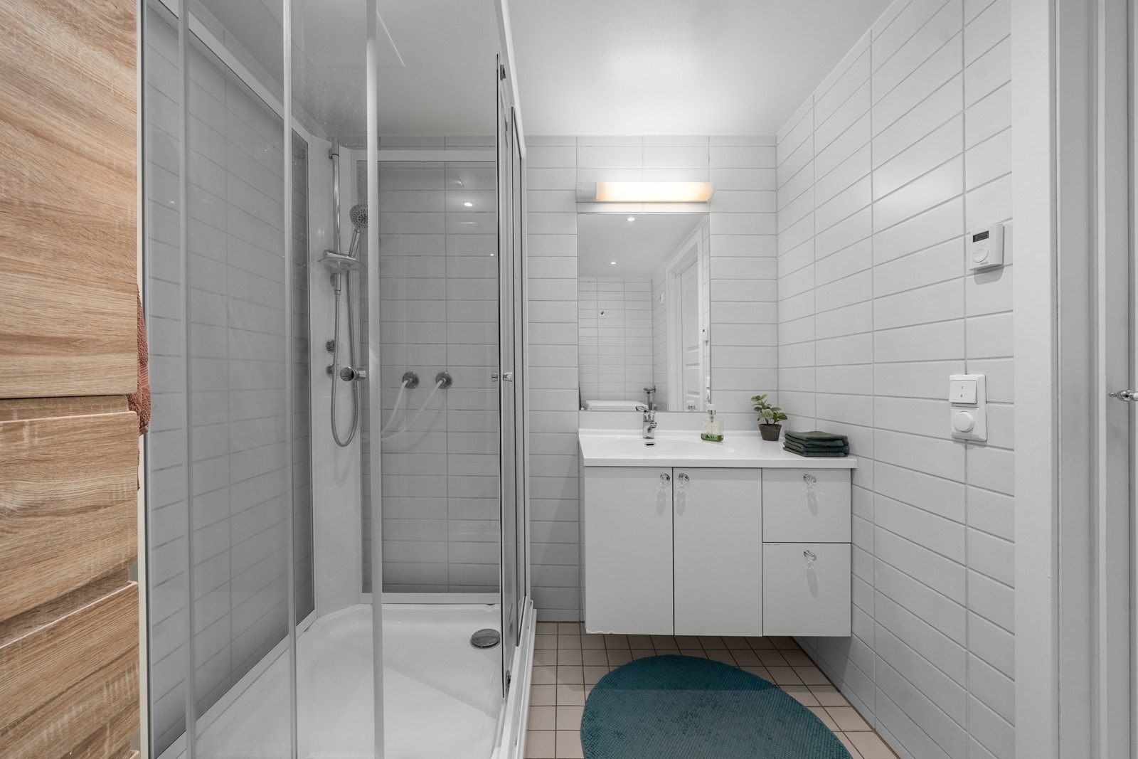 Baderomsinnredning med servant, underskap og speil med belysning. Galleribilde