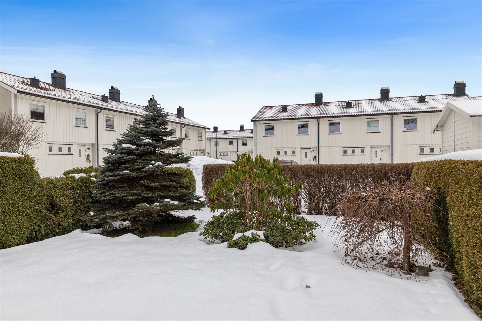 Tomten er opparbeidet slik at hver bolig får sitt eget, skjermede uteområde. Denne leiligheten disponerer en svært tiltalende hagedel med stor terrasse, paviljong og gressplen. Galleribilde