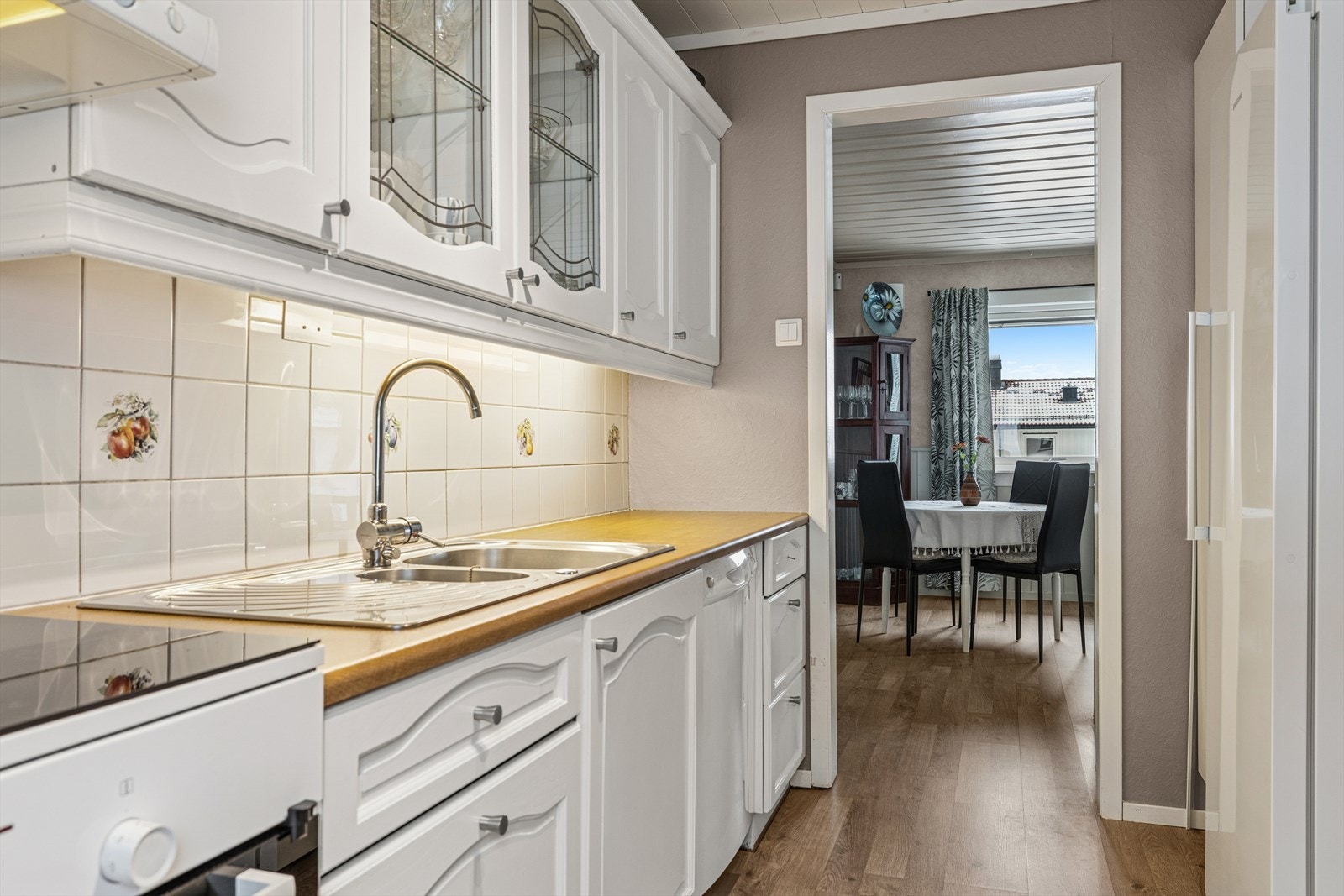 Kjøkken, innredning med profilerte fronter og laminert benkeplate. Fronter er malt for ca 4 år siden. Stålkum med ett grep blandebatteri. Flis på vegg under overskap. Galleribilde