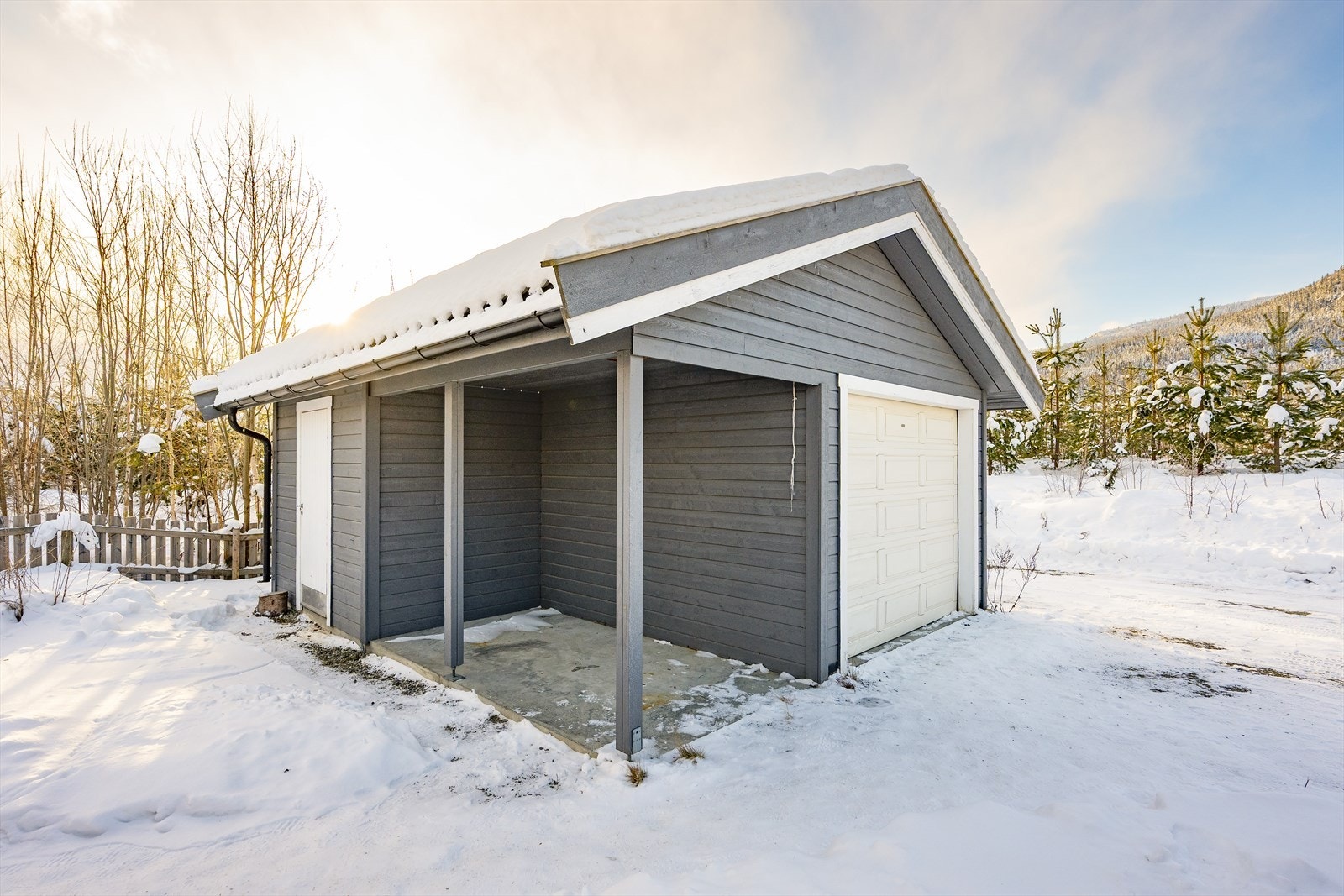 Garasjen har leddport av metall m/garasjeportåpner og innlagt strøm. Galleribilde