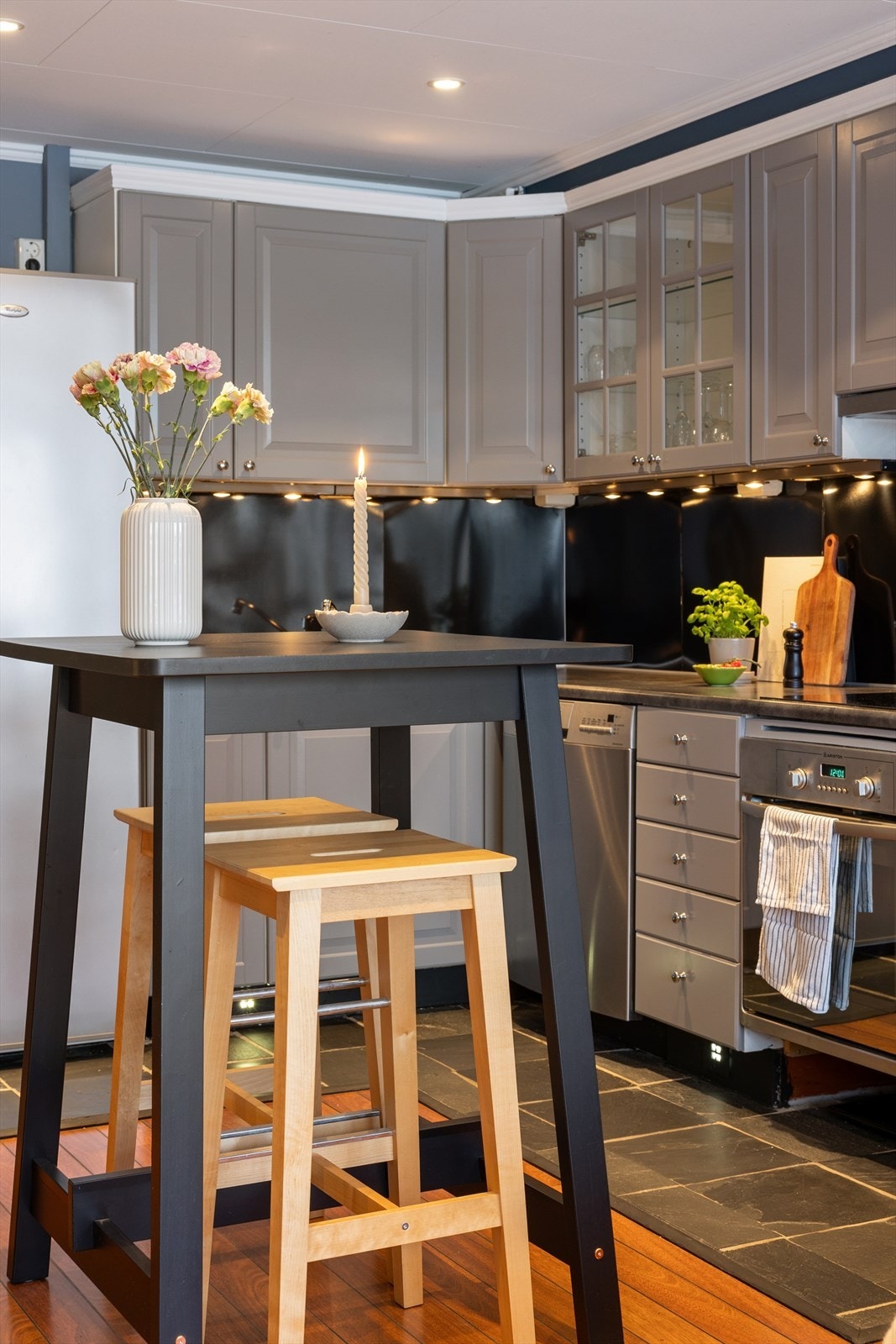 Kjøkkenet er utstyrt med frittstående kjøleskap, oppvaskmaskin i benk, stekeovn og en nedfelt induksjon platetopp. Galleribilde