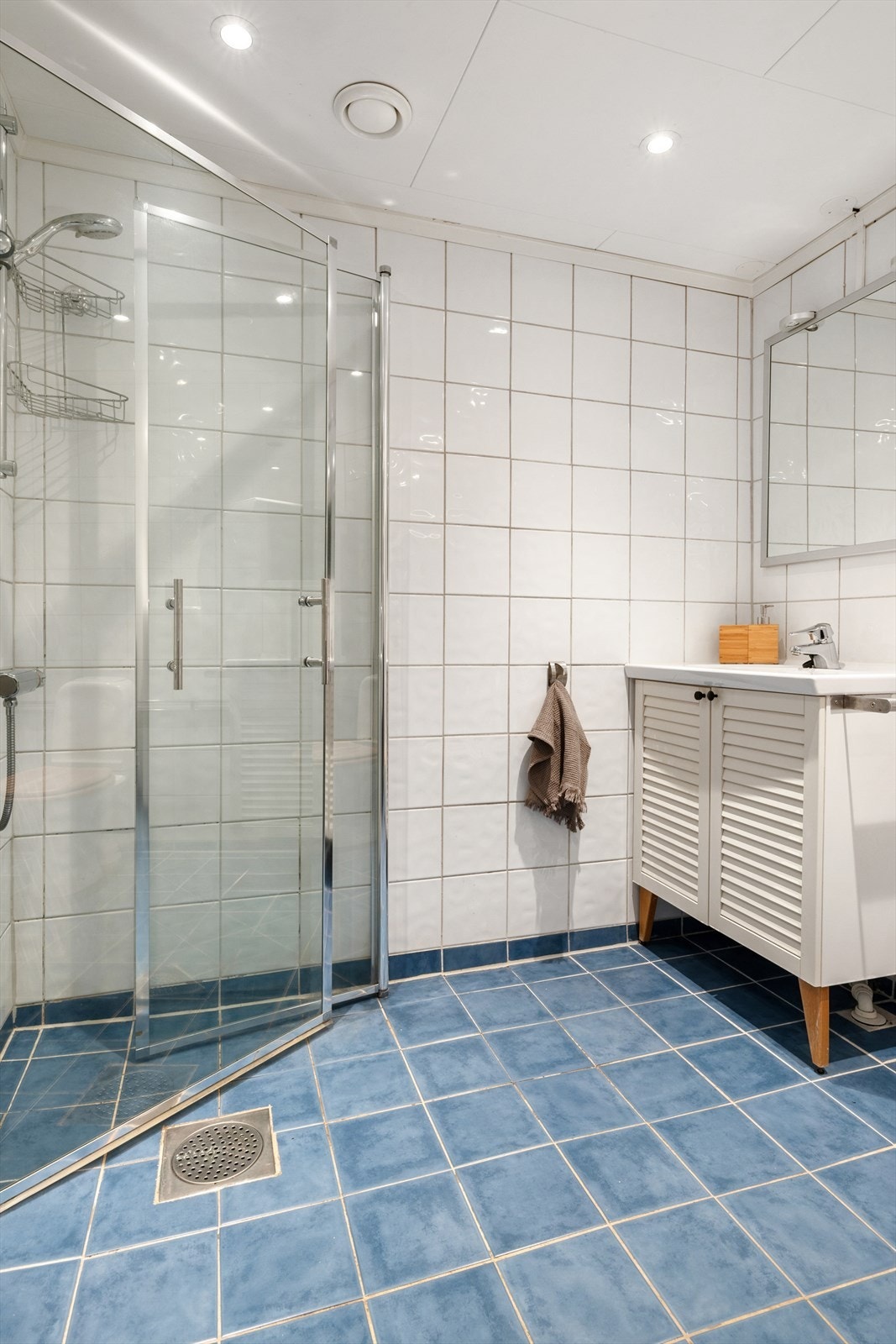 Det inneholder et vegghengt servantskap med en overliggende servant og ett-greps armatur. Vegghengt speil og lys er også en del av interiøret. Galleribilde