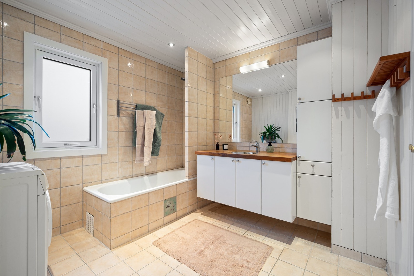 Flislagt bad med varmekabler. Hvit tidløs innredning. Dusjhjørne med innbygd badekar. Galleribilde