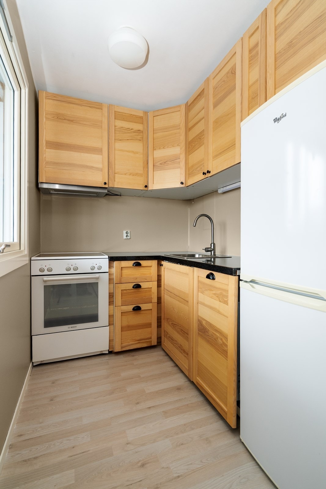 Kjøkkenet har frittstående komfyr og kjøleskap. Galleribilde