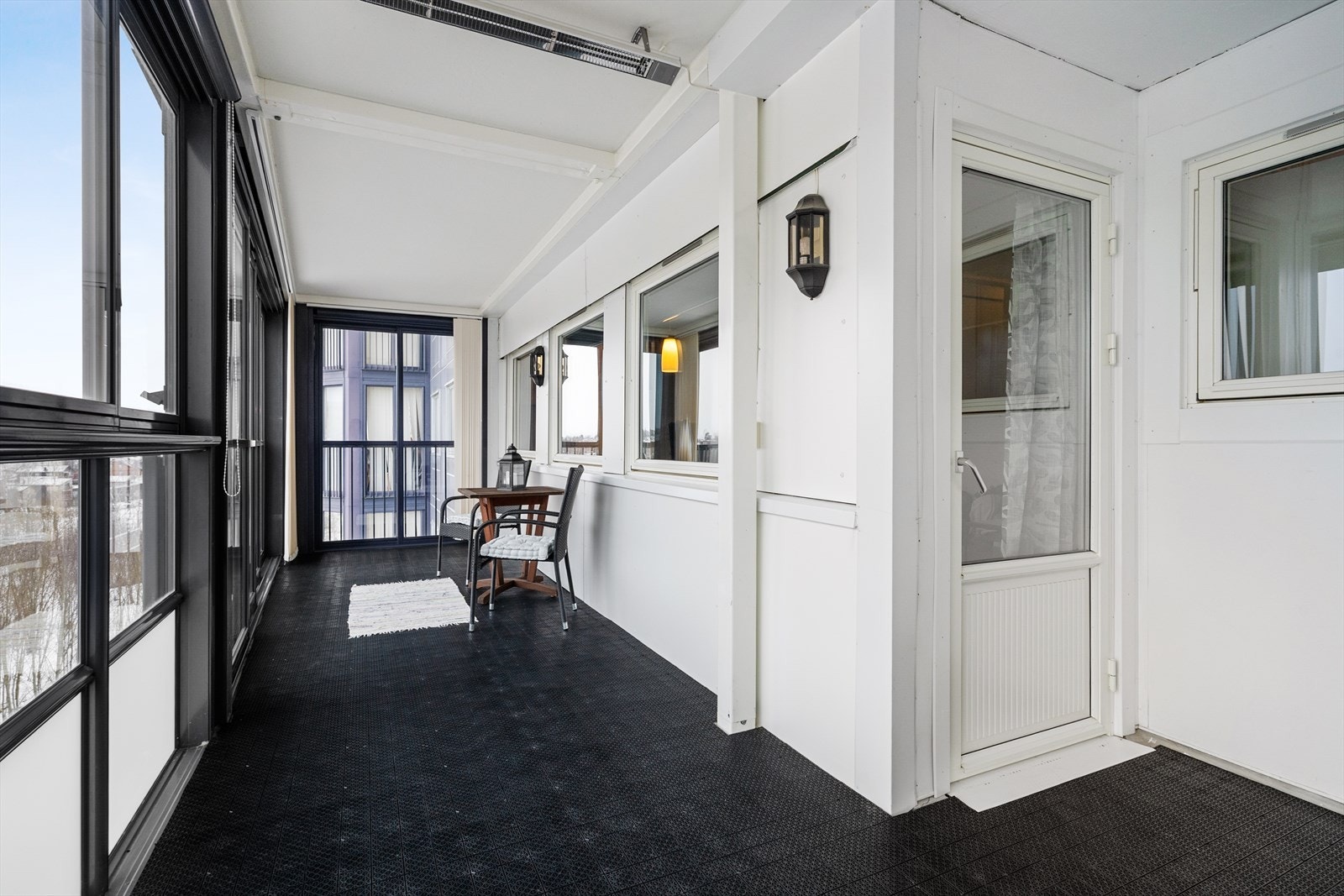 Utgang fra stue til en romslig, innglasset balkong med god plass til utemøblement - perfekt som ekstra oppholdsrom store deler av året. Galleribilde