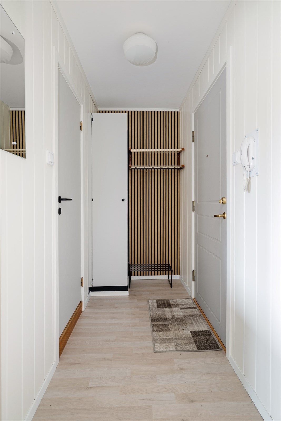 Med adkomst fra felles trappegang og heis kommer man inn i den lyse entrèen med laminat på gulvet som går videre inn i leiligheten og gir en fin helhet. Her er det skyvedørsgarderobe med speil samt oppheng for sko og yttertøy. Galleribilde