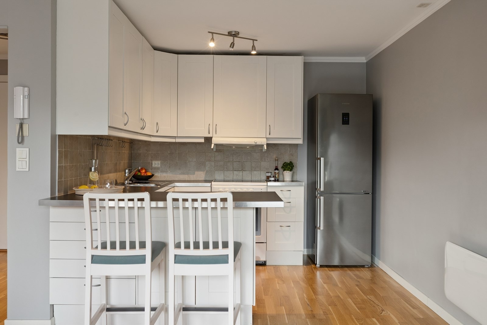 Kjøkkenet har en praktisk barløsning og innredning med klassiske, profilerte fronter. Galleribilde