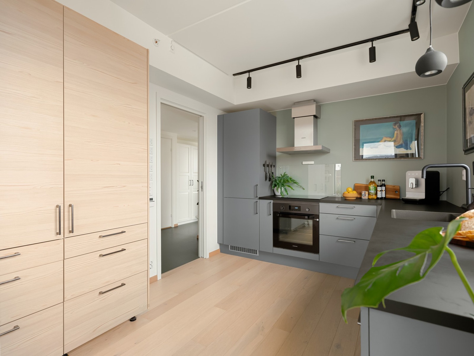 Mellom kjøkkenet og gangen er det en praktisk skyvedør som skjermer de to soverommene mot den sosiale sonen i stuen. Galleribilde