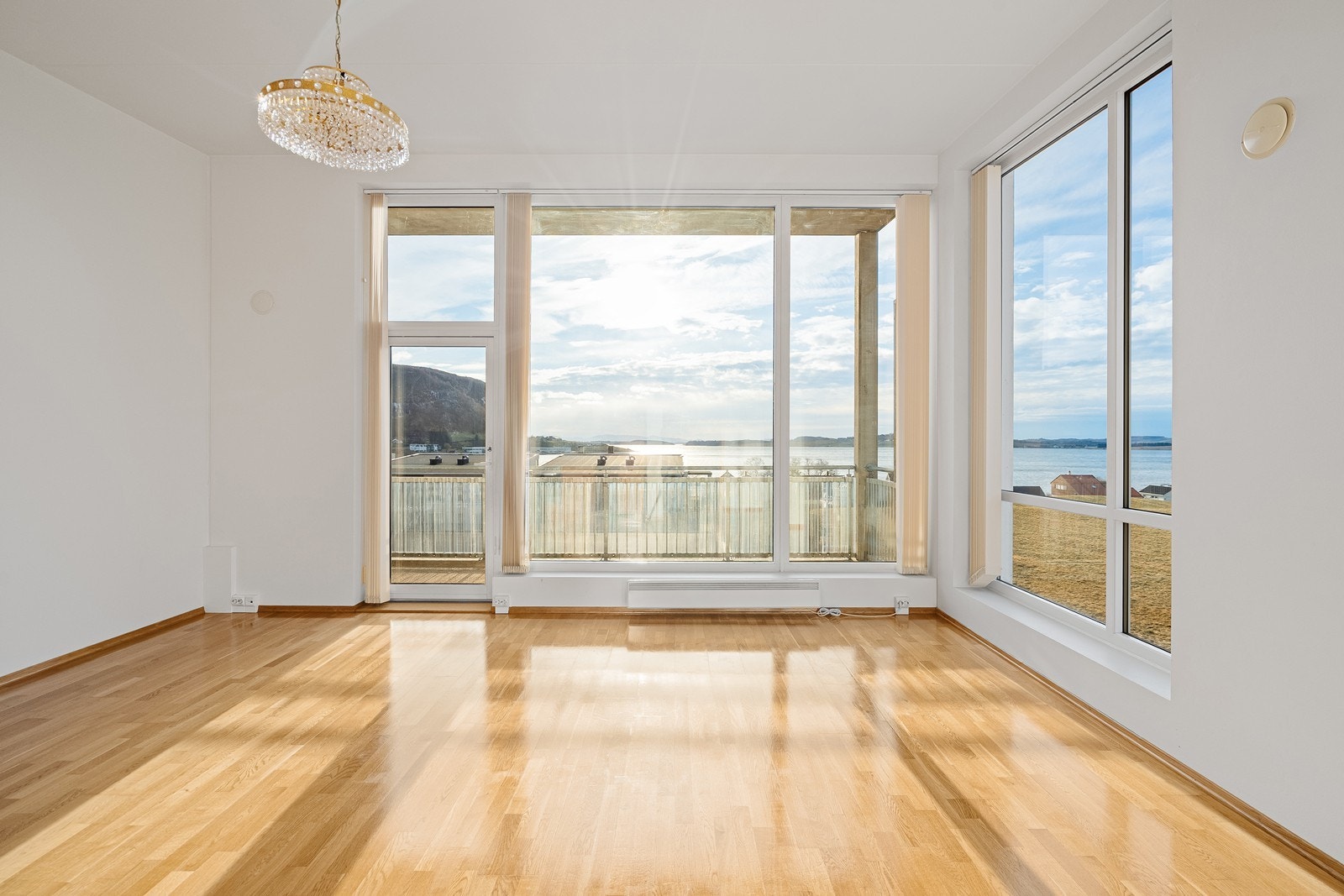 Lys og luftig stue med balkong og åpen kjøkkenløsning. Galleribilde