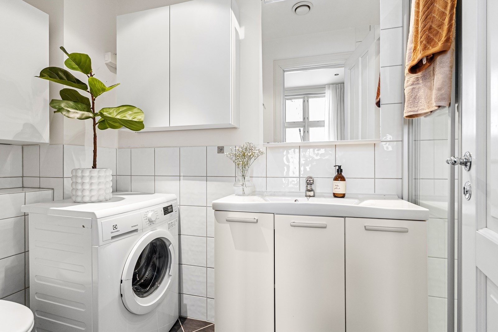 Praktisk bad med flislagt gulv og flis samt malte overflater på vegger. Galleribilde