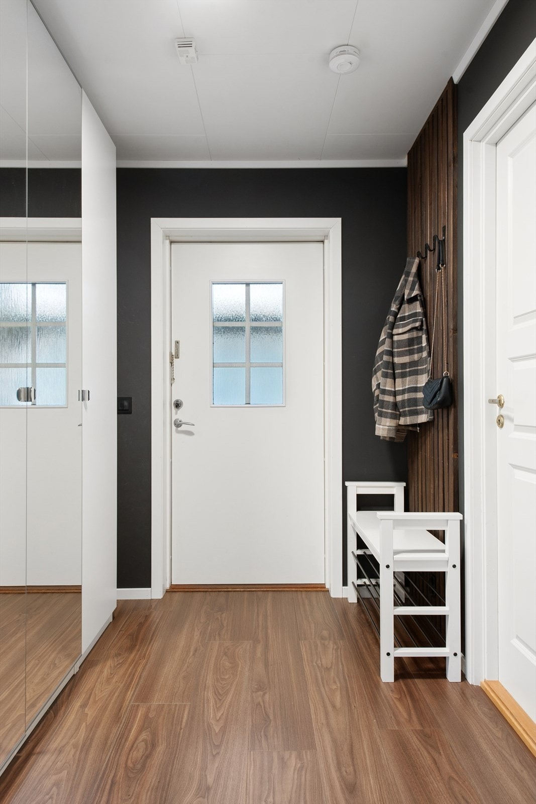 Her ønskes du velkommen inn i en lys og romslig entrè med praktisk speil- og skyvedørsgarderobe. Galleribilde