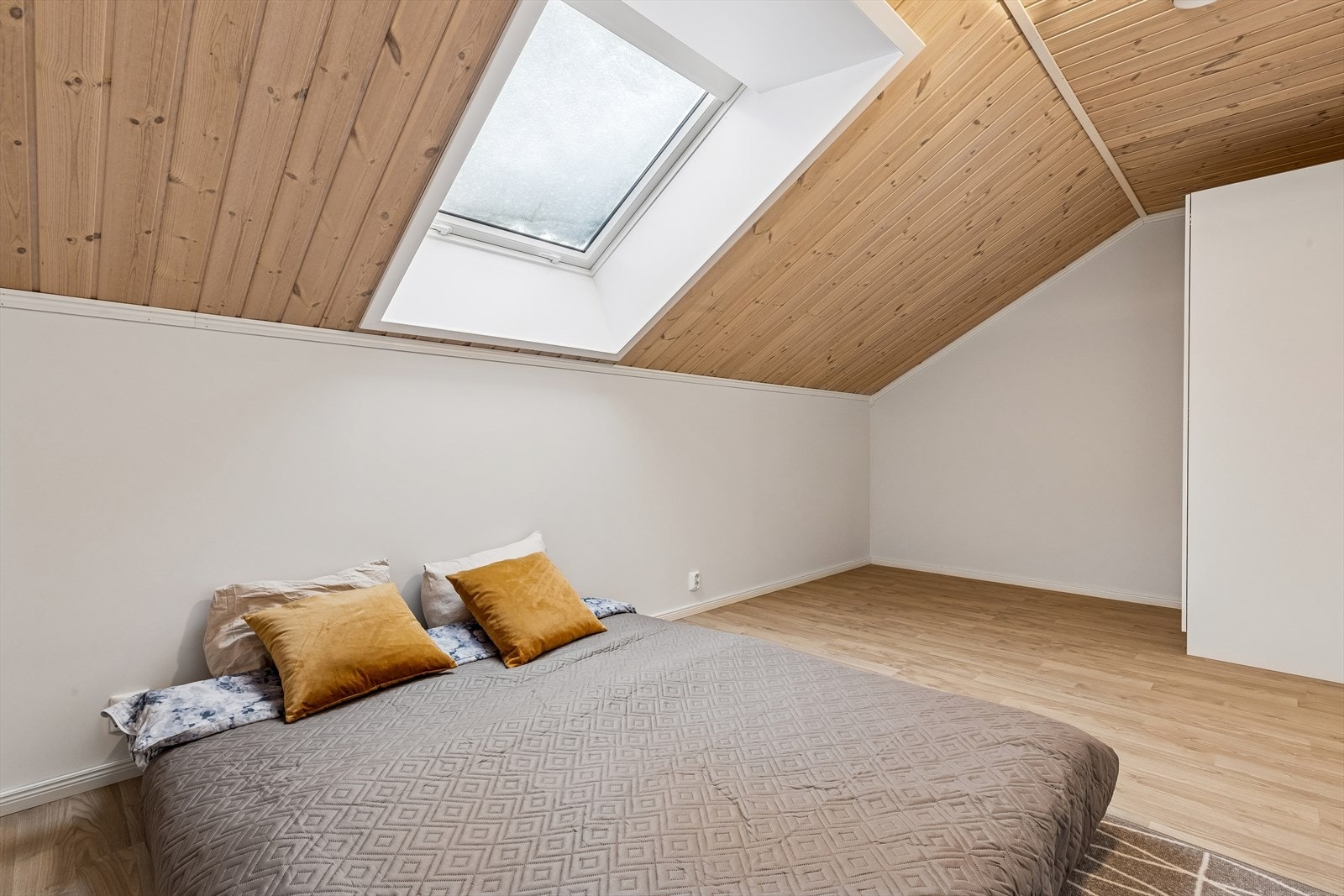 Soverommet på loftet har en lun atmosfære med takvindu og trepanel i himling. Galleribilde