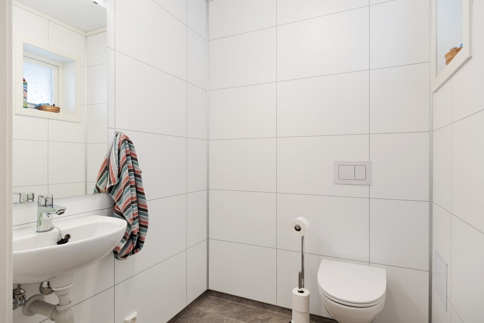 Praktisk toalettrom i 1. etasje med enkel servant og vegghengt toalett. Galleribilde