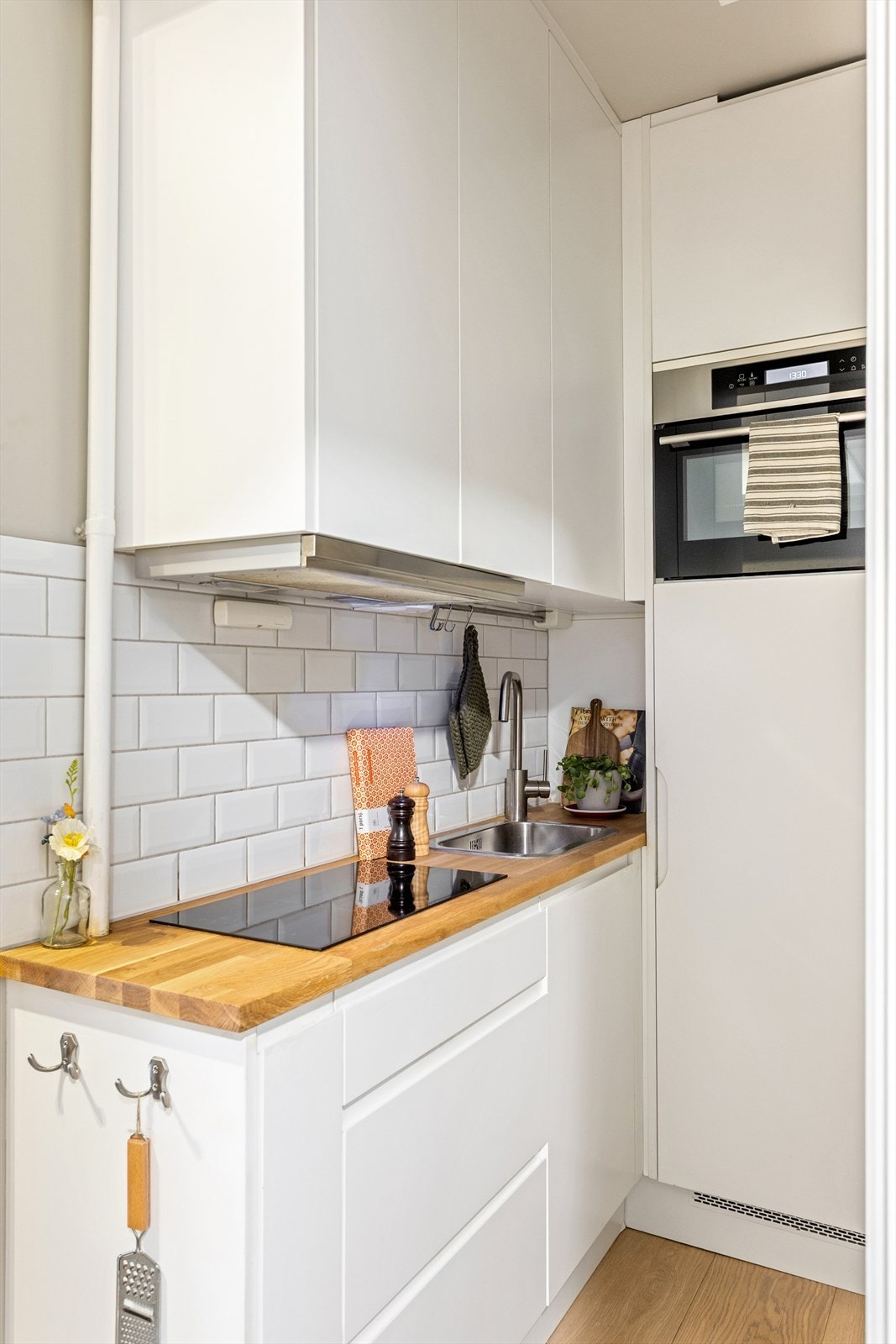 Kjøkkeninnredningen består av glatte skapfronter med over- og underskap som gir god oppbevaringsplass. Benkeplaten er i heltre, og det er montert nedfelt platetopp og oppvaskkum. Galleribilde