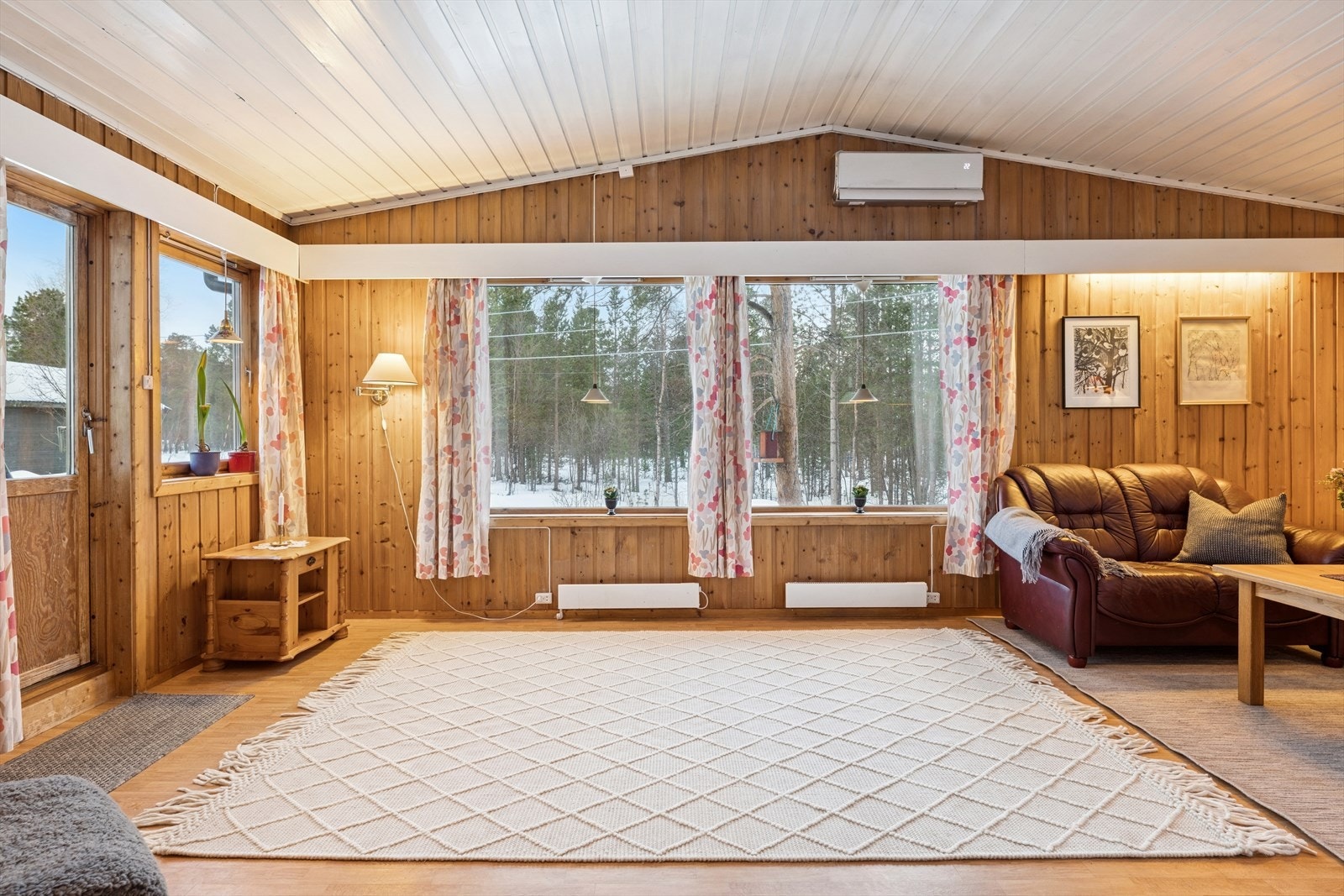 Deler av stuen har ekstra god takhøyde, noe som gir rommet en romslig og åpen atmosfære. De store vindusflatene slipper inn rikelig med naturlig lys og bidrar til en lys og innbydende stue. Galleribilde