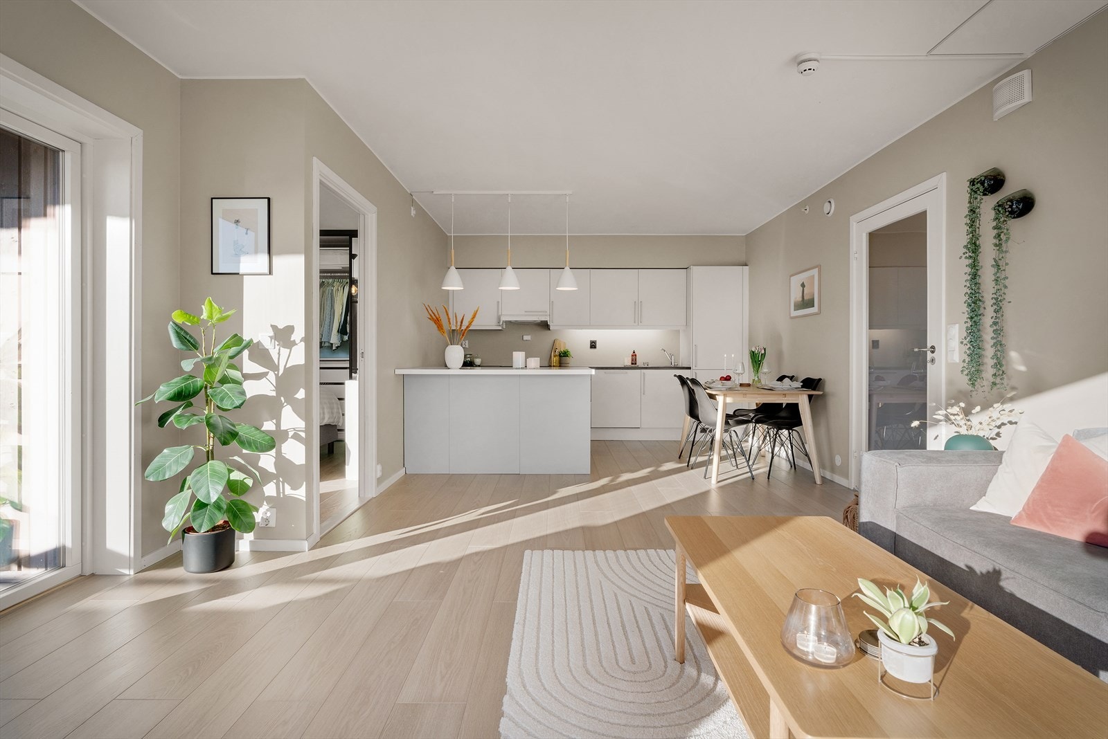 Fra balkongen beveger du deg videre inn i leilighetens åpne stue- og kjøkkenløsning. Galleribilde