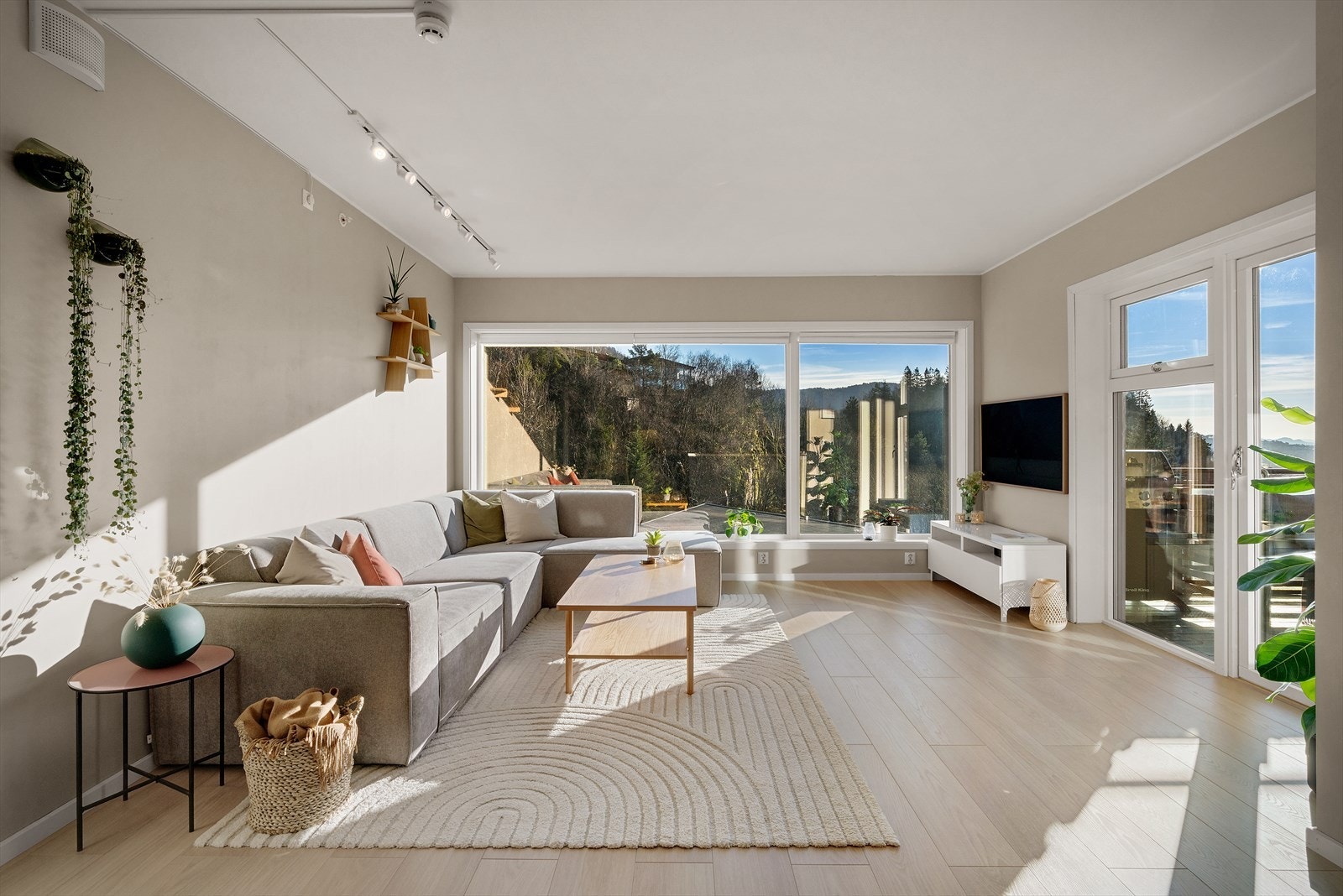 Velkommen inn! Her møtes du av en romslig, åpen stue- og kjøkkenløsning med store vindusflater. Galleribilde