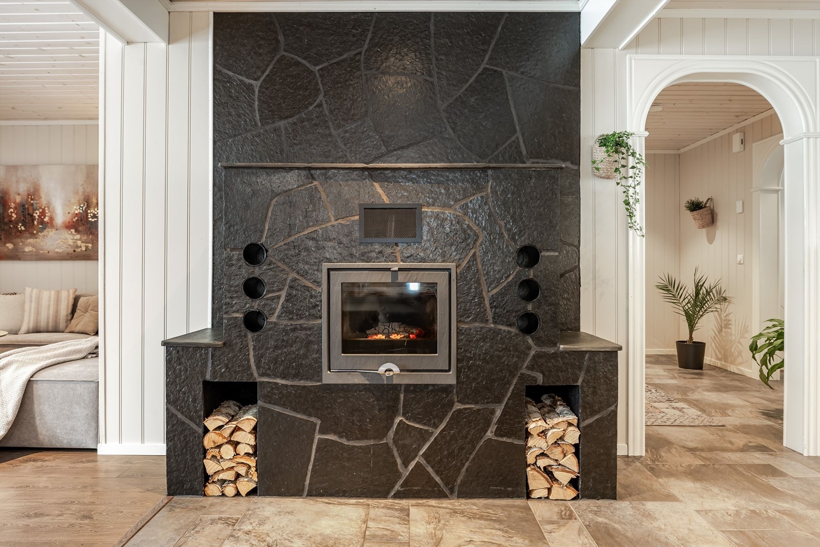 Som et fint midtpunkt i stuen har du en murt peis med skiferstein og peisinnsats som bidrar til ekstra hygge på kaldere høst- og vinterdager. Galleribilde