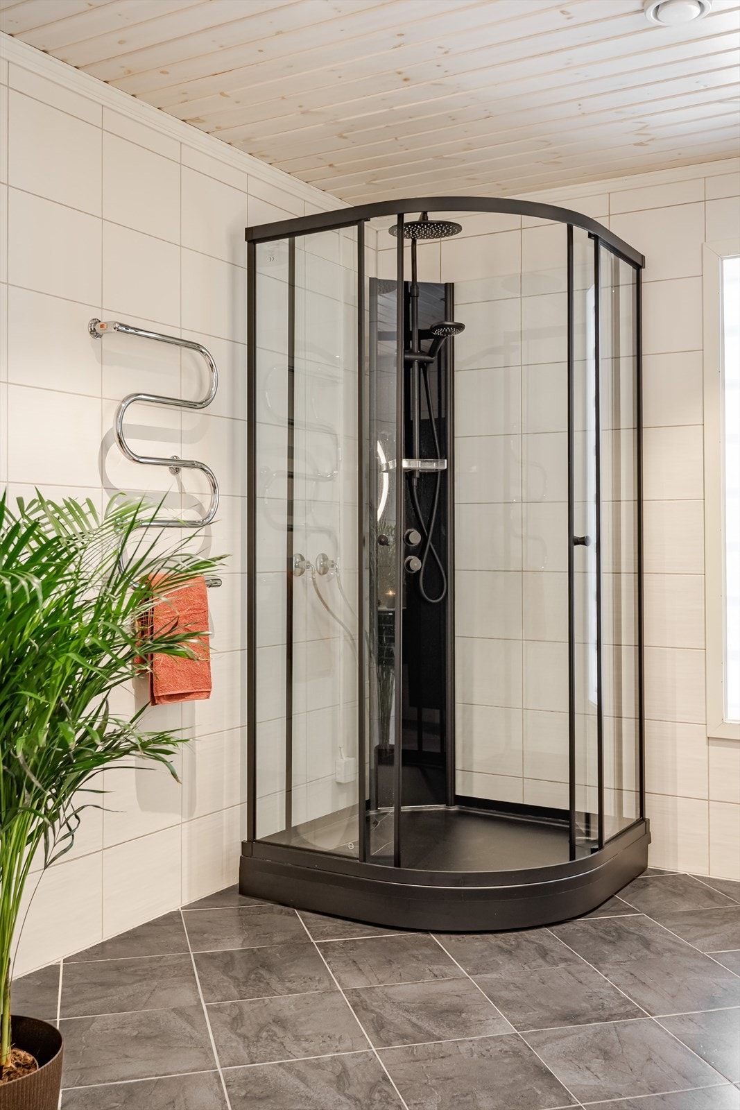 Moderne dusjkabinett fra 2025 med sorte detaljer og både hånd- og regnfallsdusj. Baderommet er også utstyrt med vegghengt toalett. Galleribilde